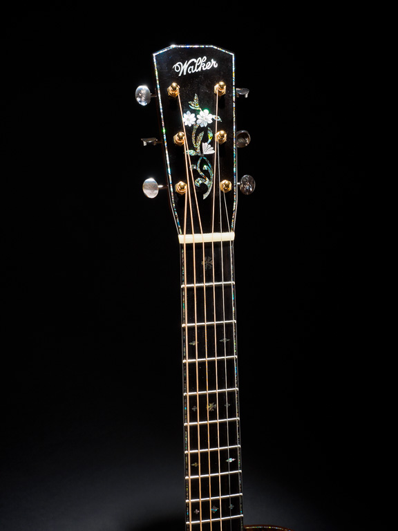 Blue paua headstock and fingerboard purfling. Flower vine headstock inlay. Black mother-of-pearl tuner buttons and snowflake inlay's