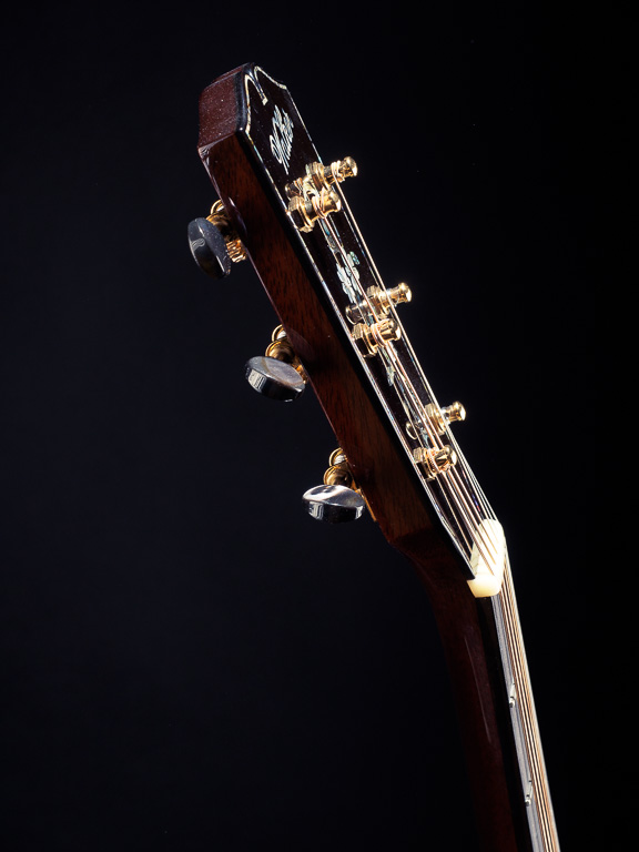 Black mother-of-pearl tuner buttons on a tapered headstock