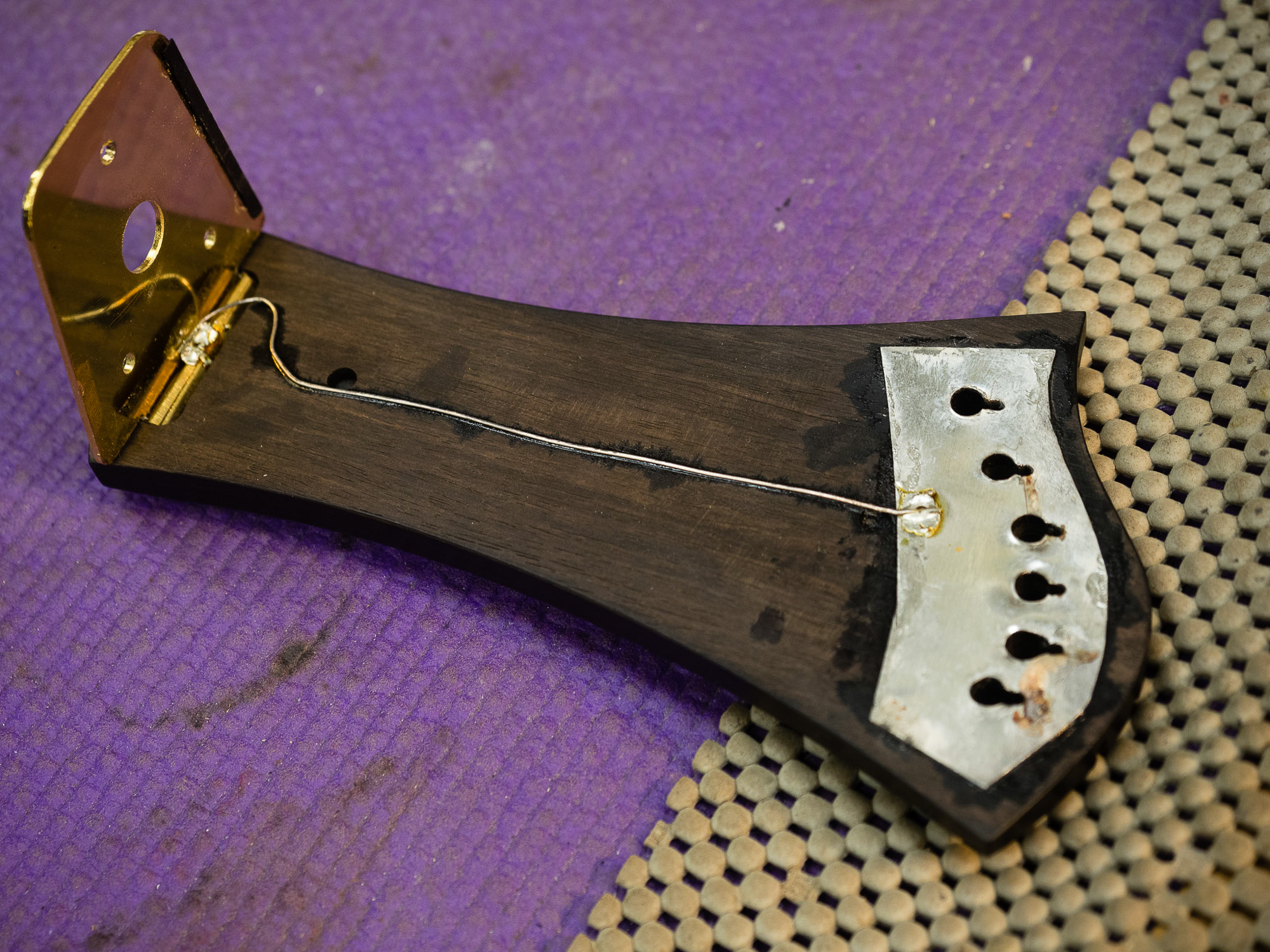 The underside of the tailpiece showing the hinge and ugly craftsmanship